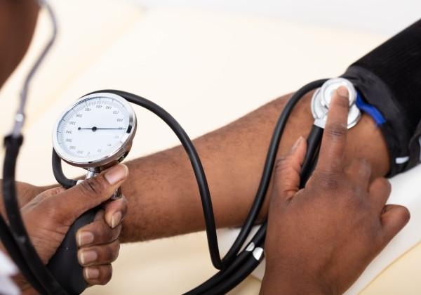 Close-up of a person checking someone's blood pressure.